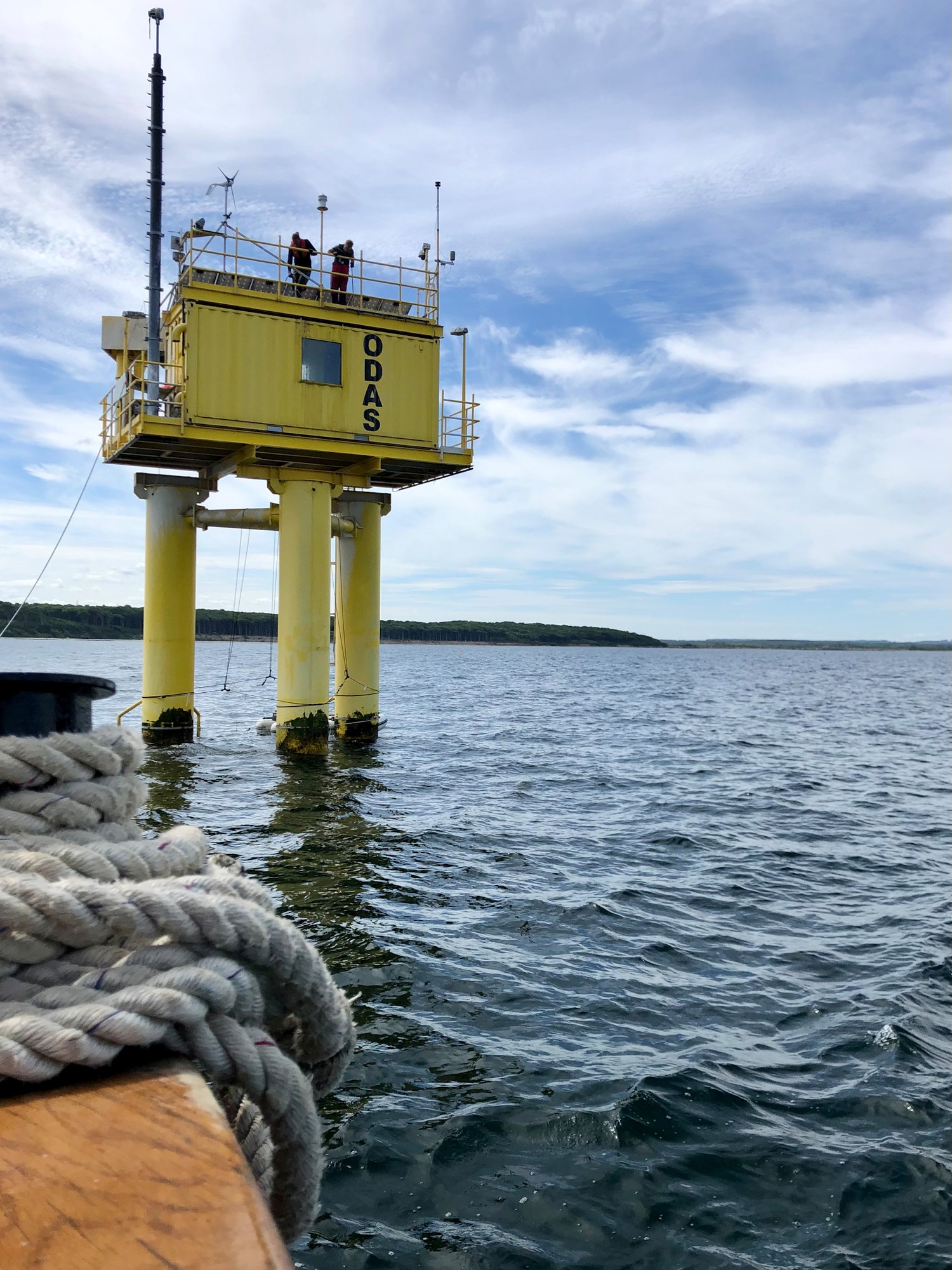 Gelber Container mit Funkmast auf drei Pfeilern mitten in der Ostsee